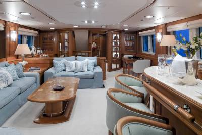 Elegant light blue sofas and a polished wood coffee table create a serene lounge area on this luxurious yacht.
