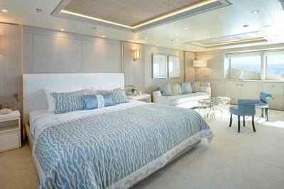 Luxurious yacht bedroom with ocean views, plush bedding, and elegant seating for ultimate relaxation.