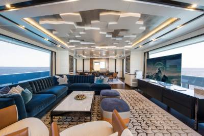 Luxurious yacht interiors offer breathtaking ocean views through expansive windows, complemented by plush seating and modern entertainment systems.