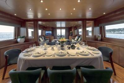 Dine in elegant style aboard this yacht, surrounded by rich wood paneling and panoramic ocean views.