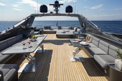 Enjoy a luxurious outdoor dining experience on the deck of this magnificent yacht, surrounded by the sparkling blue sea.