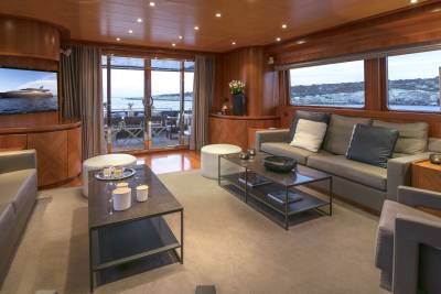 Relax in this luxurious yacht salon with stunning ocean views through expansive windows and sliding doors.