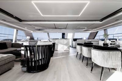 Luxurious yacht interiors feature sleek modern furniture and expansive windows offering breathtaking ocean views.