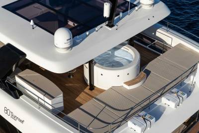 A luxurious yacht features a circular jacuzzi and spacious sundeck with life rafts and a Cypriot flag.
