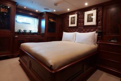 Luxurious mahogany paneling and plush bedding create an opulent sanctuary aboard this elegant yacht.