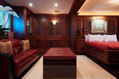 Luxurious cherry wood paneling and rich red leather furnishings create an opulent ambiance in this yacht's master suite.