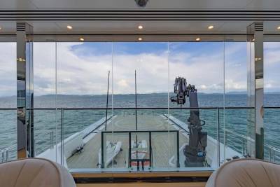 Luxurious yacht interiors offer stunning ocean views through floor-to-ceiling windows, showcasing a helideck and crane.