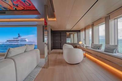 A luxurious yacht interior offers stunning ocean views and modern comfort with sleek furniture and artistic ceiling details.