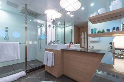 Luxurious yacht bathroom features a sleek glass shower, modern vanity with ample storage, and elegant marble flooring.