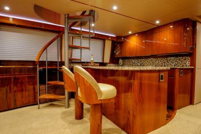 Luxurious wood finishes and a spiral staircase create an elegant galley on this yacht.