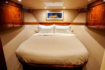 Luxurious wood-paneled stateroom with a queen-sized bed and vibrant underwater artwork offers a serene escape at sea.