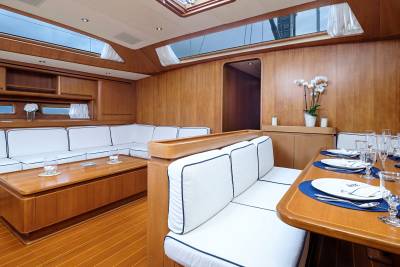 Luxurious wooden interiors and white upholstered seating create an elegant dining and lounging space aboard this yacht.