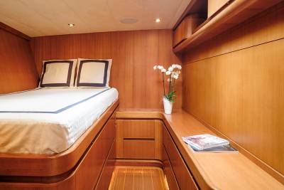 Luxurious wood paneling and a plush bed create a cozy retreat aboard this elegant yacht.
