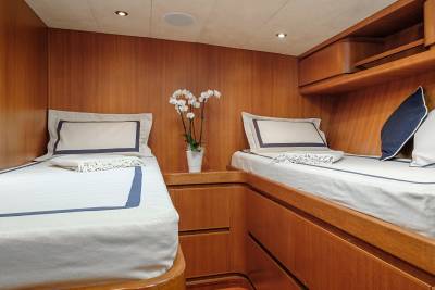 Luxurious wooden cabins offer a serene retreat with crisp white bedding and elegant floral accents.