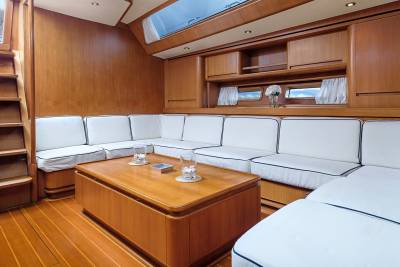 Luxurious white upholstery and warm wood paneling create a serene and inviting salon aboard this elegant yacht.