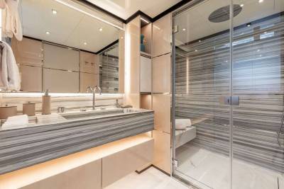 Luxurious marble and glass create a serene spa-like atmosphere in this modern yacht bathroom.