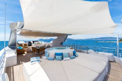 Relax in the sun or soak in the jacuzzi on the expansive deck of this luxurious yacht.