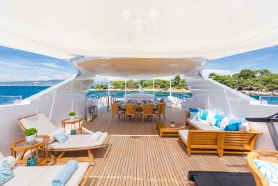 Luxurious yacht deck seating and dining areas offer a perfect spot to enjoy the stunning coastal scenery.