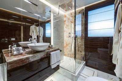 Luxurious marble and rich wood create a spa-like sanctuary in this opulent yacht bathroom.