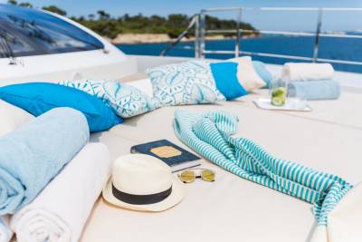 Relax on the deck of a luxury yacht with refreshing drinks, a good book, and comfortable cushions.