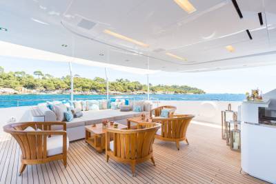 Luxurious yacht deck seating offers a perfect vantage point for enjoying the turquoise waters and lush green coastline.