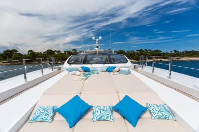 Relax on the spacious sun deck of this luxurious yacht, surrounded by the azure sea and lush green coastline.