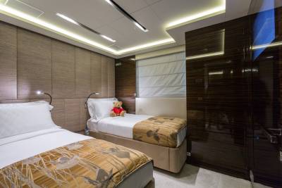 Luxurious twin beds with plush bedding and a charming teddy bear create a cozy retreat in this elegant cabin.