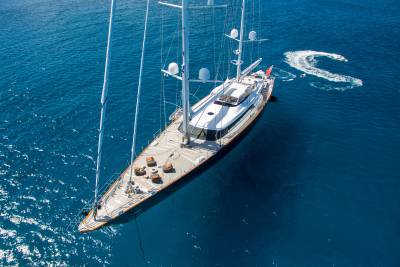 A majestic yacht glides through the deep blue ocean, leaving a foamy wake behind it.