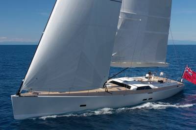 A sleek white sailboat glides through the deep blue ocean under a clear sky.