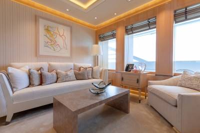 This luxurious yacht salon offers a serene ambiance with its neutral tones, elegant furnishings, and expansive windows overlooking the water.