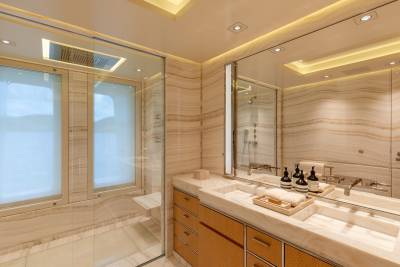 Luxurious marble and warm wood finishes create a serene and elegant atmosphere in this modern yacht bathroom.