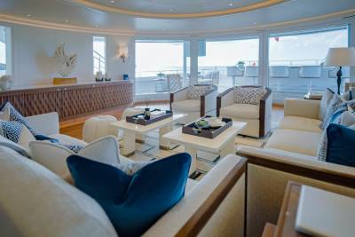 Luxurious yacht interiors feature plush seating and panoramic windows overlooking the ocean.