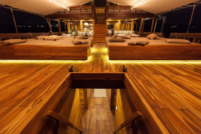 Luxurious wooden decks and plush seating offer an inviting ambiance for nighttime relaxation aboard this elegant vessel.