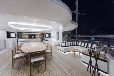 Luxurious yacht deck seating and dining areas offer elegant outdoor living spaces illuminated by soft evening light.