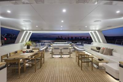 Enjoy a luxurious al fresco dining experience on this yacht's expansive deck as the sun sets over the distant coastline.