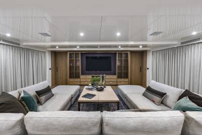 Plush sofas and a sleek entertainment center create a luxurious living space aboard this modern yacht.