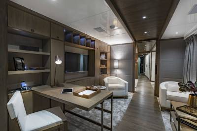 A modern office space features a sleek desk, comfortable seating, and integrated shelving with ambient lighting.