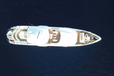 A sleek white yacht glides through the deep blue ocean, its decks inviting relaxation and exploration.