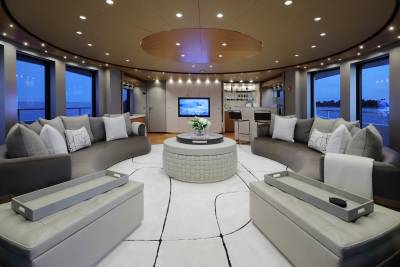 This luxurious yacht lounge offers a serene retreat with plush seating, a well-stocked bar, and stunning ocean views.
