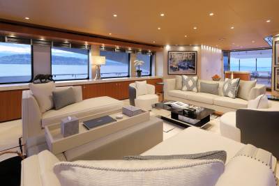 Luxurious yacht interiors offer serene views of the water from plush seating areas.