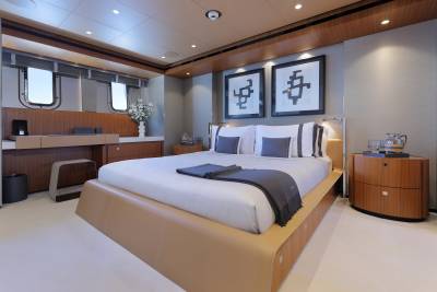 Luxurious yacht accommodations feature a spacious bed, elegant artwork, and a serene ambiance.