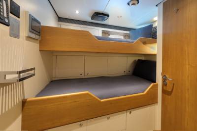 Bunk beds with sleek wooden accents and navy blue bedding offer a cozy sleeping space within this modern cabin.