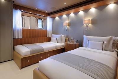 Luxurious twin beds with crisp white linens and elegant wooden accents create a serene retreat.