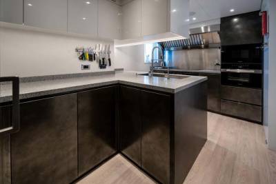 A sleek, modern kitchen features dark cabinetry, granite countertops, and stainless steel appliances.