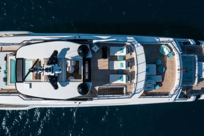 A luxurious yacht with a helipad and swimming pool glides across the deep blue ocean.