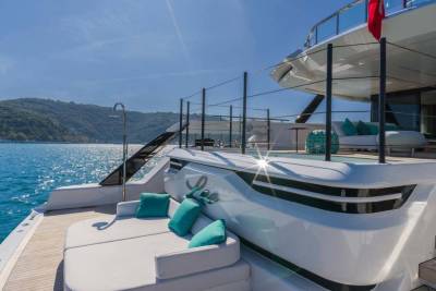Luxurious yacht decks offer comfortable seating and stunning ocean views under a clear blue sky.