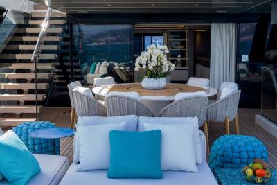 Luxurious outdoor seating and a dining area on a yacht deck offer a serene setting for enjoying the ocean view.