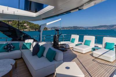 Relax on the spacious deck of a luxury yacht, surrounded by turquoise waters and a picturesque coastline.