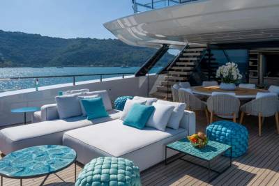 Relax on the spacious deck of a luxurious yacht, surrounded by stunning ocean views and comfortable outdoor seating.