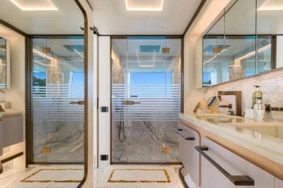 This luxurious yacht bathroom features a spacious glass-enclosed shower and elegant marble countertops.